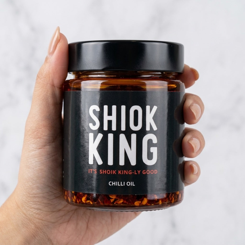 Hand holding a jar of Shiok King Original Chilli Oil